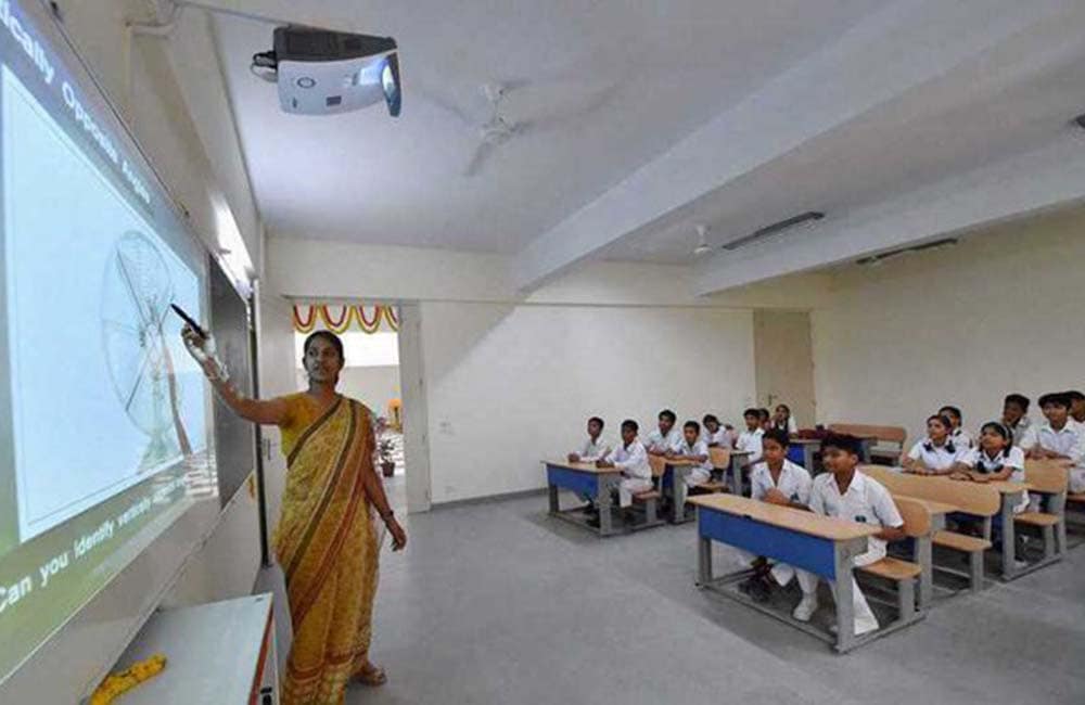 A teacher leading a lesson at the smartboard in a Vikas Juniors classroom